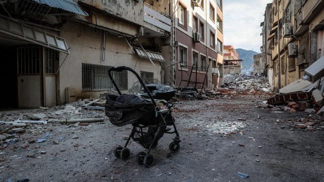 Изоставена детска количка пред срутени сгради в Антакия център на