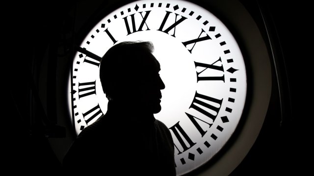 Часовникарят Хесус Лопес Терадас стои пред един от циферблатите на часовниковия механизъм