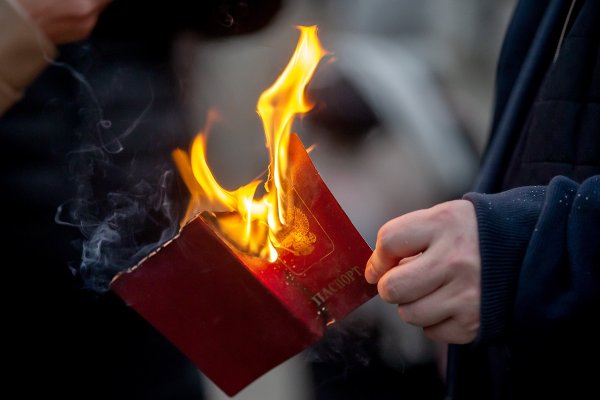 Мъж изгаря руския си паспорт пред руското посолство в Кишинев, Молдова. Снимка: БГНЕС/EPA/DUMITRU DORU