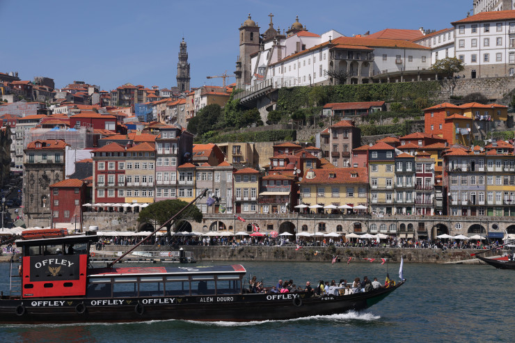 Туристически лодки, рекламиращи марки местно вино, минават по река Дуеро в Порто. Фотограф: Шон Галъп/Getty Images
